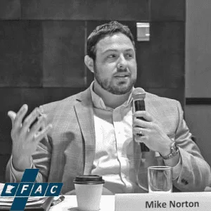 Speaker holding a microphone at a panel discussion.